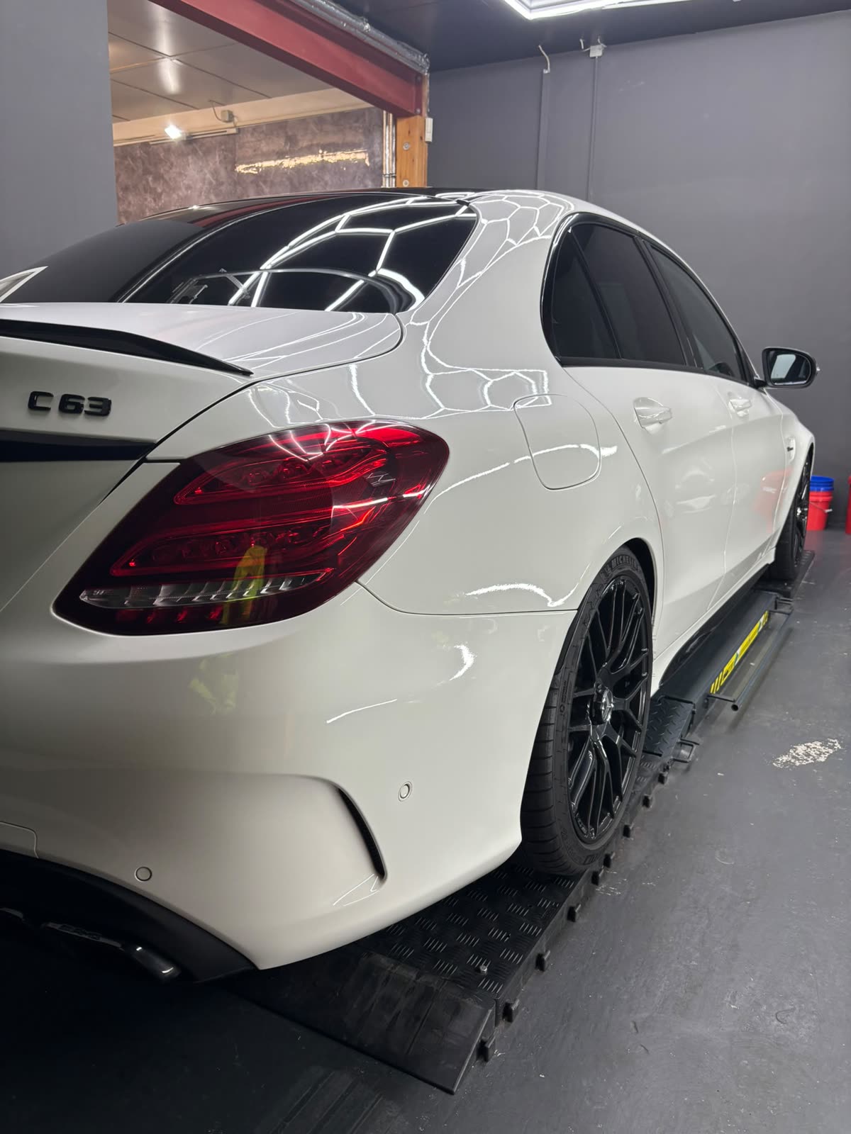 Heck eines weißen Mercedes-AMG C 63 mit AMG-Schmiederädern nach der Aufbereitung