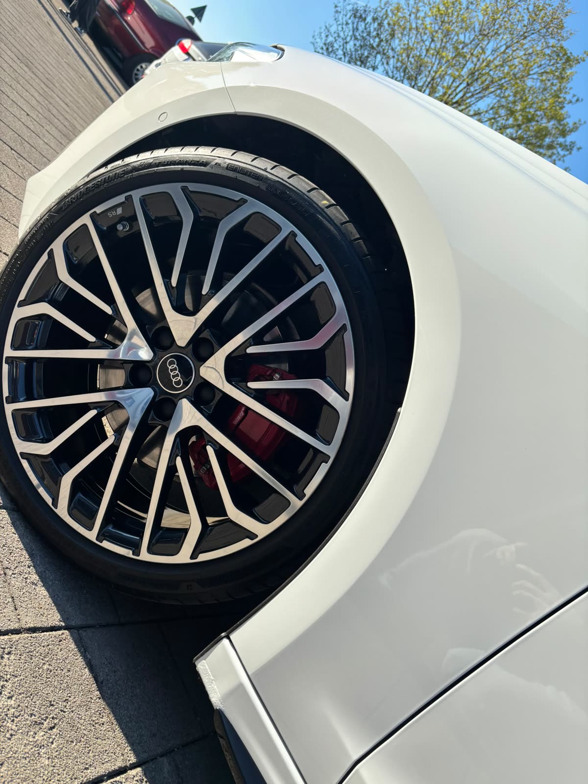 Zweifarbige Audi-Felge mit rotem Bremssattel und sauberem Radhaus