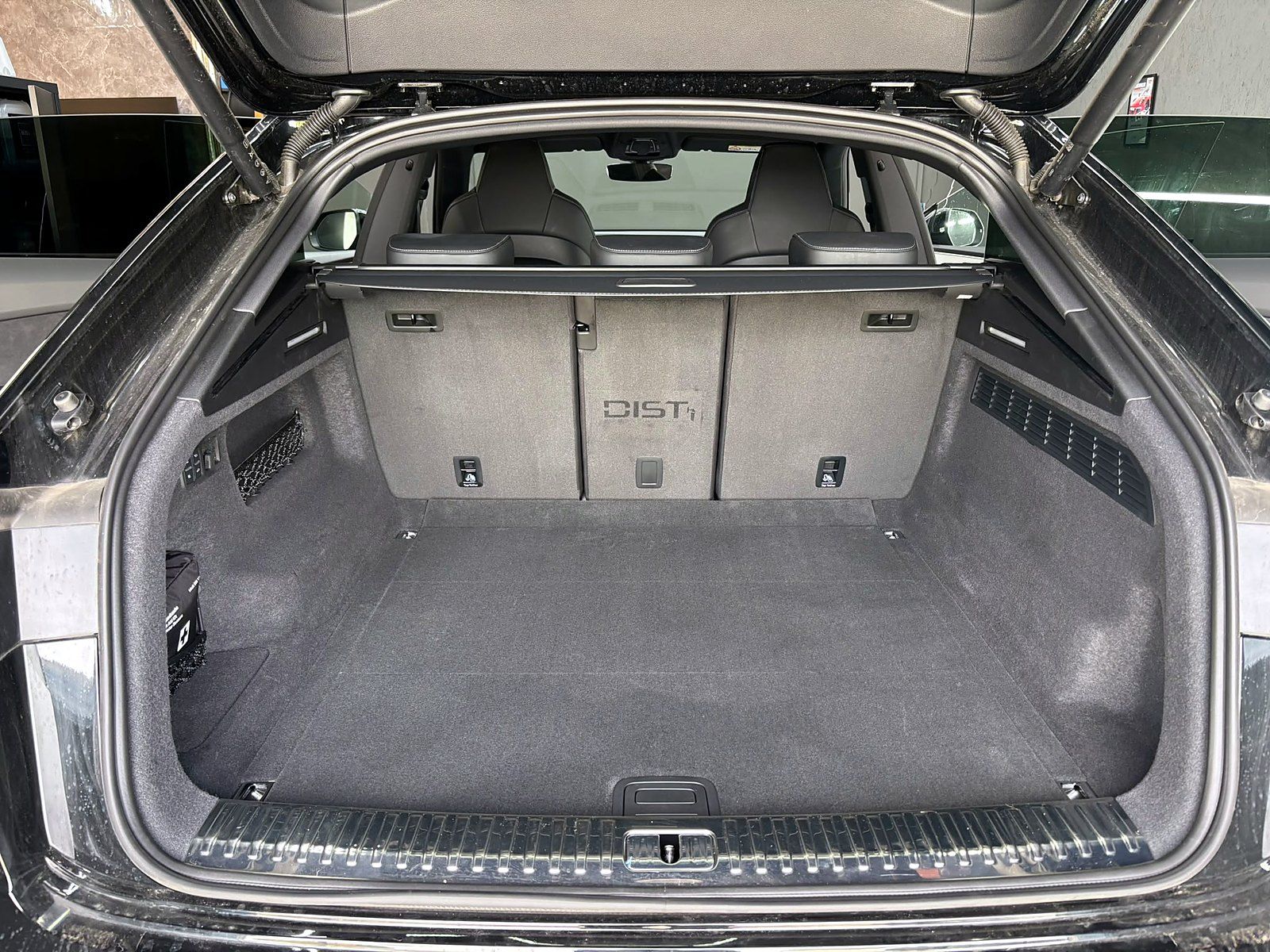 Gereinigter Kofferraum eines Audi Kombi, der DIST-Schriftzug ist ins Teppichflor gekämmt