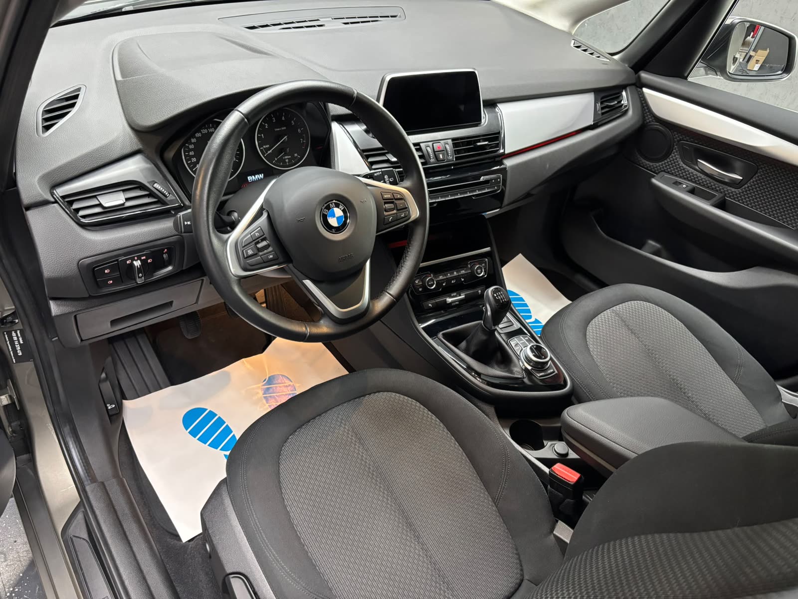 Gereinigtes Cockpit eines BMW 2er mit ausgelegtem Schutzpapier im Fußraum