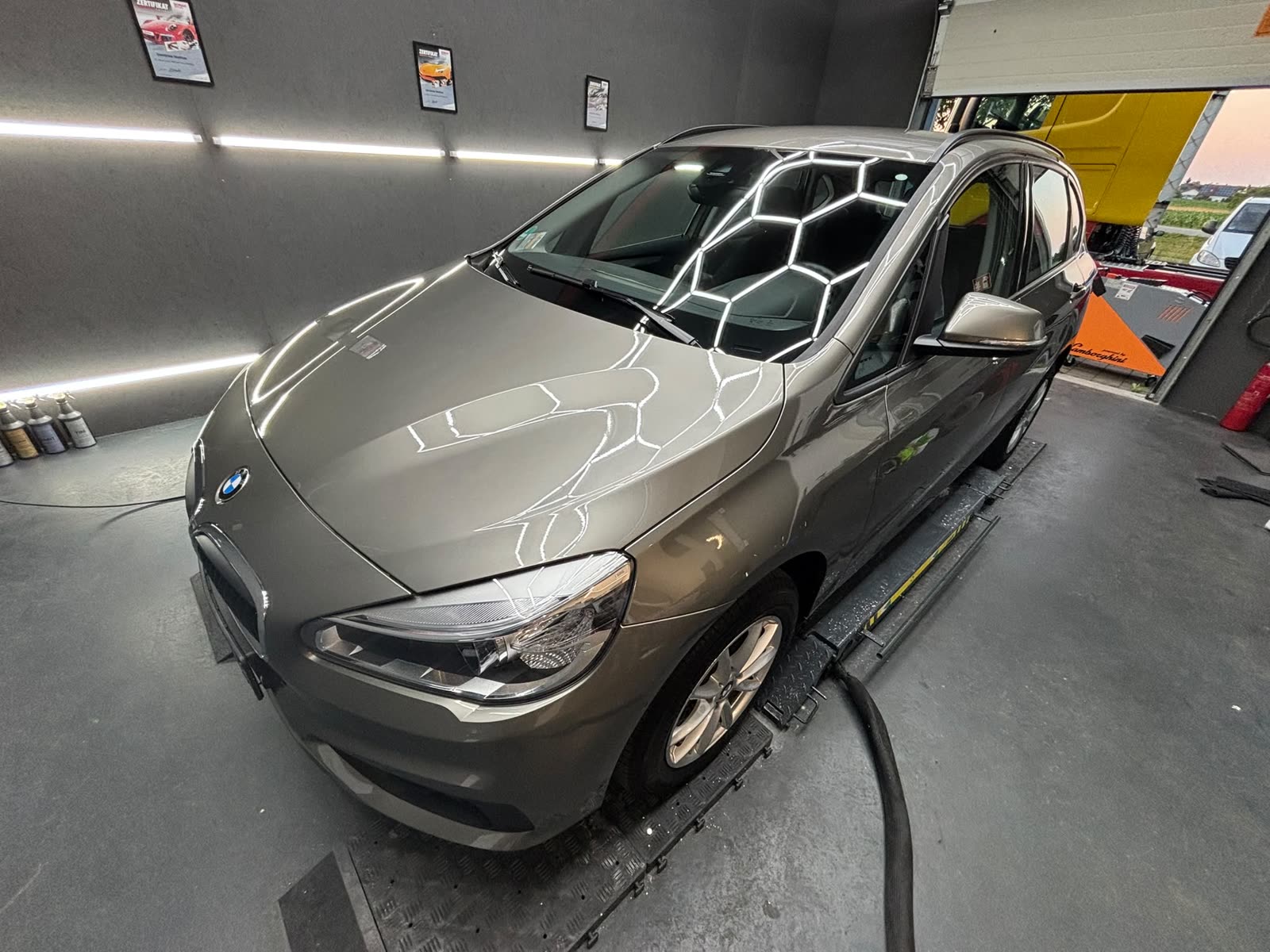 Grauer BMW 2er Gran Tourer in der Halle unter der Wabenbeleuchtung