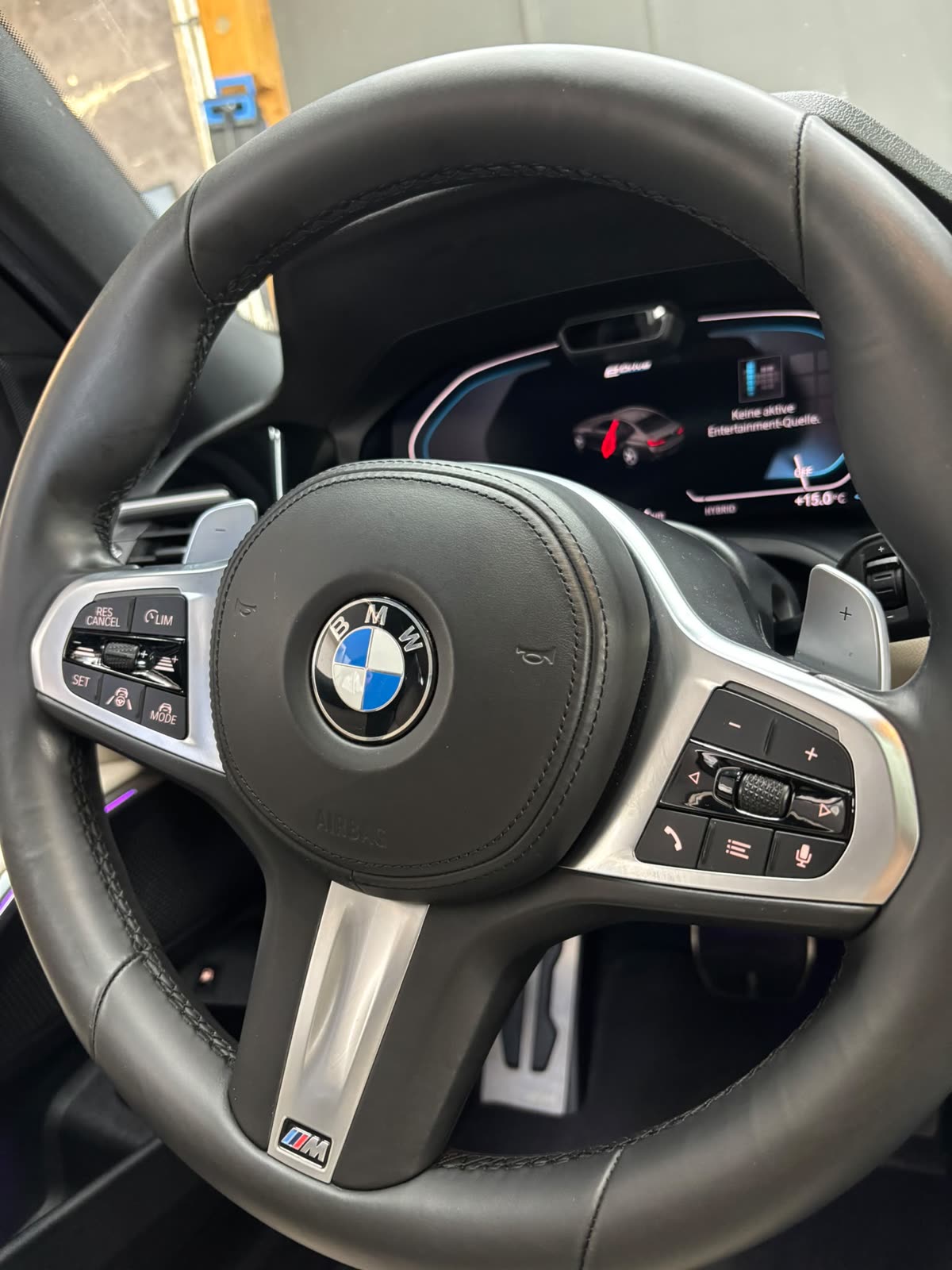 Gereinigtes M-Lenkrad eines BMW vor dem digitalen Kombiinstrument