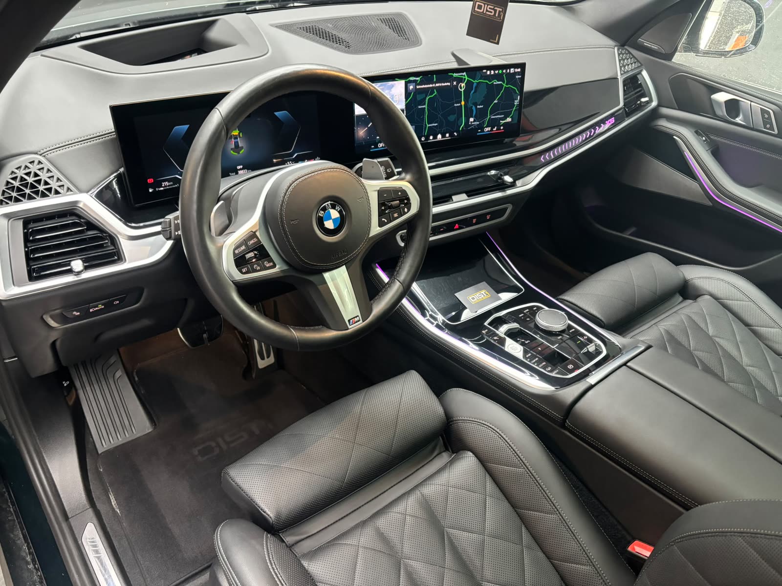 Aufbereitetes Cockpit eines BMW X5 mit Ledersitzen in Rautensteppung und Ambientebeleuchtung